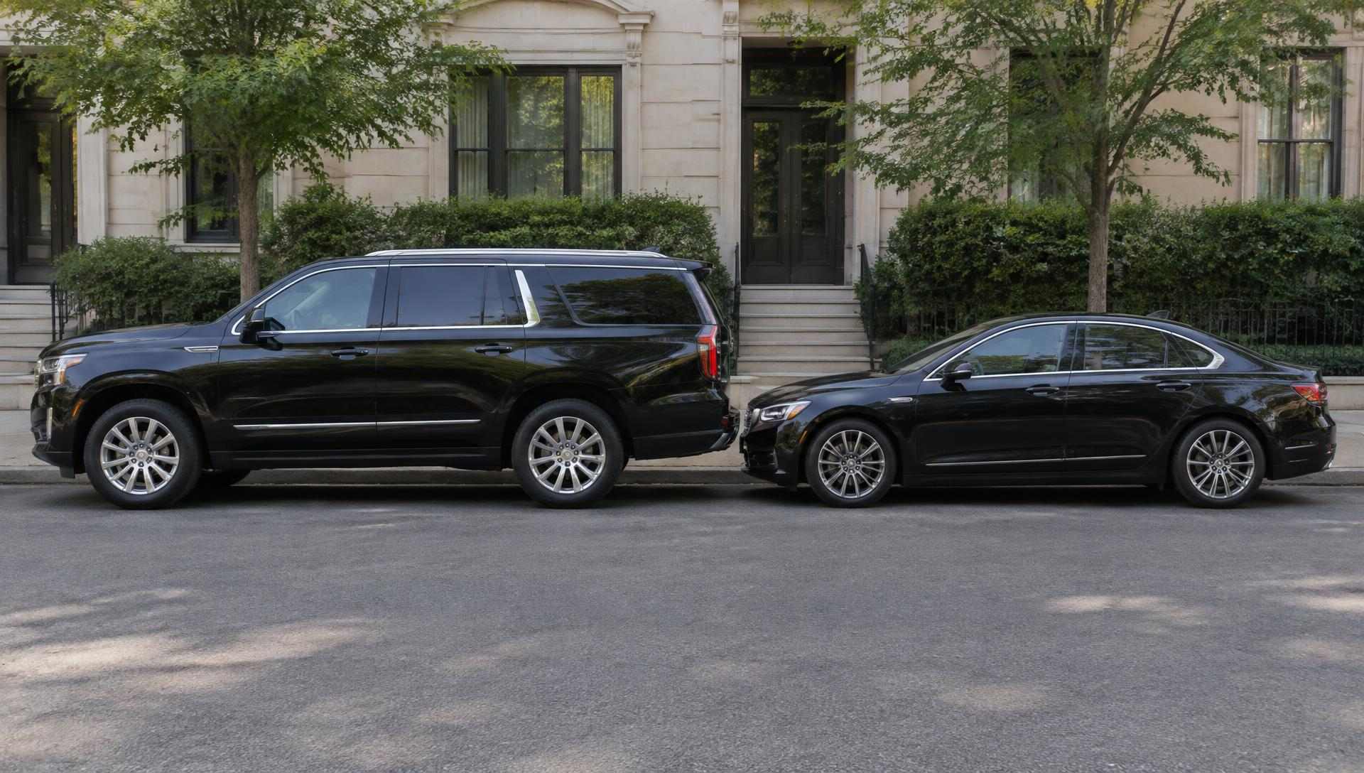 A black SUV and a black sedan parked on a quiet street
